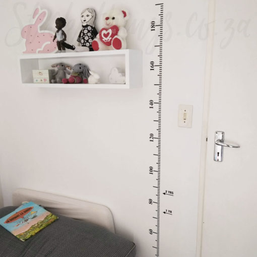 The Growth Chart Wall Sticker is stuck to a wall in a kids room