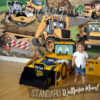 Little Boy standing in fron of his Under Construction Bulldozer Wall Mural
