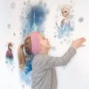 Girl sticking her Disney Ice Palace Frozen Glitter Wall Decal