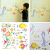 Little boy installing the Peel & Stick Watercolour Sea Creatures Wall Decals