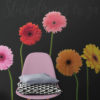 Giant Bright Gerber Flowers Wall Decals on a dark wall behind a pink chair